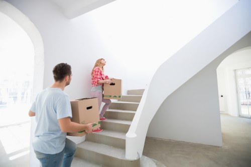 Removal team carrying items through a narrow stairwell in Kentish Town